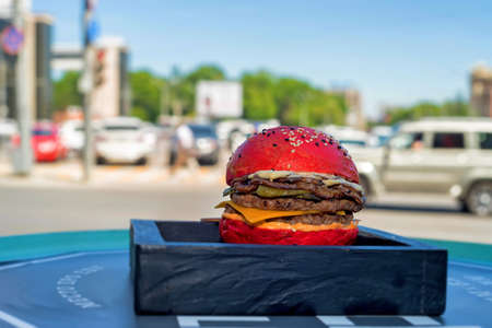 Restaurant burger with red bun on wooden boardの写真素材