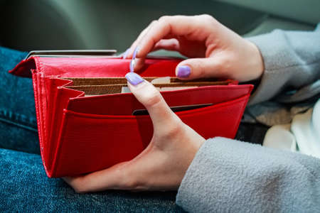 Female hands hold modern red money purse for womenの写真素材
