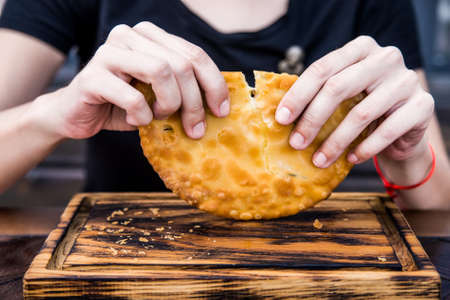Close up female hands holding freshly made Khachapuri in restaurantの写真素材