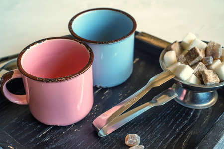 Tea set with two metal cups, sugar tongs and lumpsの写真素材