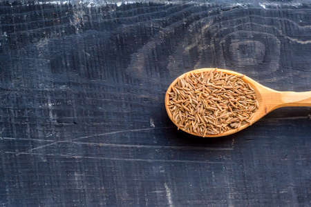 Caraway seeds in wooden spoon dark backgroundの写真素材