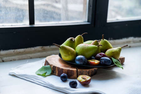 Studio shot plums and pears on plate heathy diet
