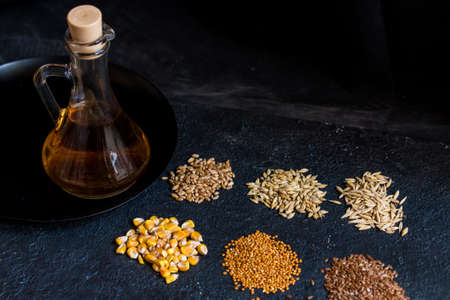 Piles of six different grains and oil in decanterの写真素材