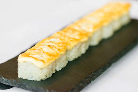 Uncut Japanese sushi roll on wooden trayの写真素材