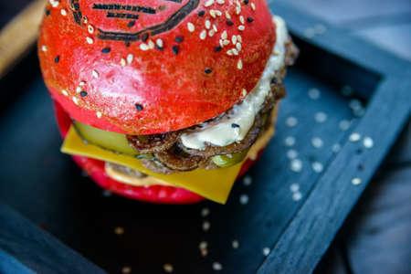 Black burger with prawns on wooden boardの写真素材