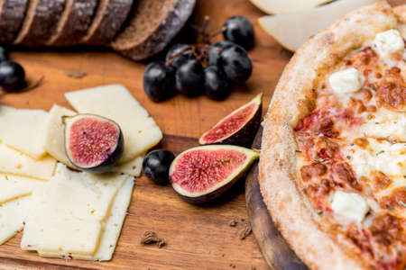 Close up pizza, figs, grapes, and cheeseの写真素材