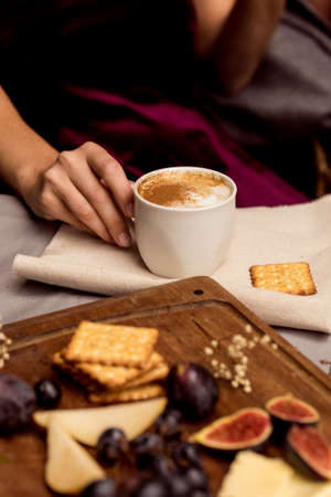 Girl in dress drinks coffee with delicious food