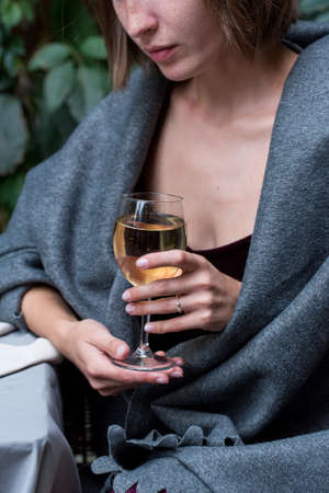 Pretty girl in blanket with glass of champagneの写真素材