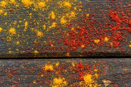Close up colorful spices red paprika powder and yellow curry on dark wooden surfaceの写真素材