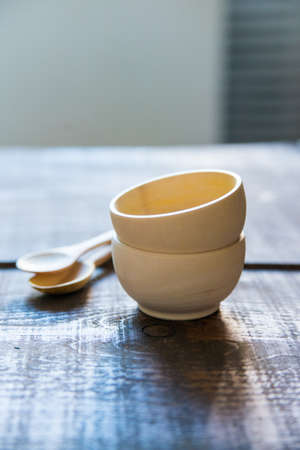 Empty wooden bowls and spoons on wooden backgroundの写真素材