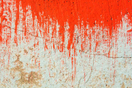 Old plaster wall partly covered in red paintの写真素材