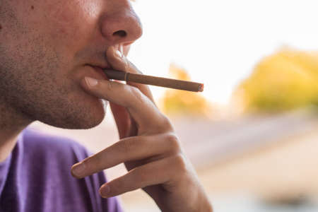 Close up man smokes cigaretteの写真素材
