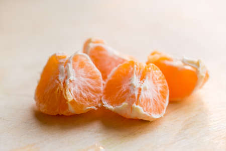 Closeup pieces of peeled tangerine on wooden boardの写真素材