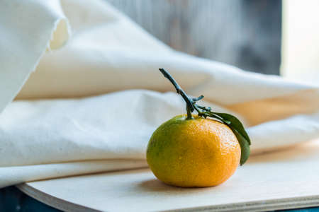 Studio shot of fresh juicy tangerine with white cloth in background winter food conceptの写真素材
