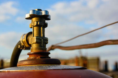 Close up image of an old gas cylinder valve with blue sky in backgroundの写真素材