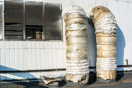 Close up wall of factory building and two big pipesの写真素材