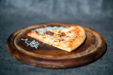 Single slice of delicious pizza on wooden trayの写真素材