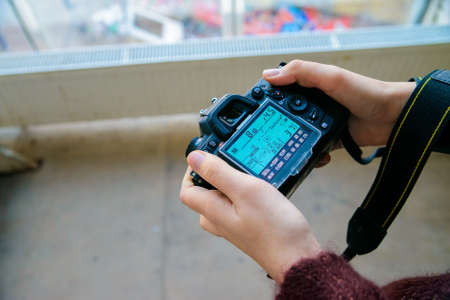 Close up female hands adjust settings on camera
