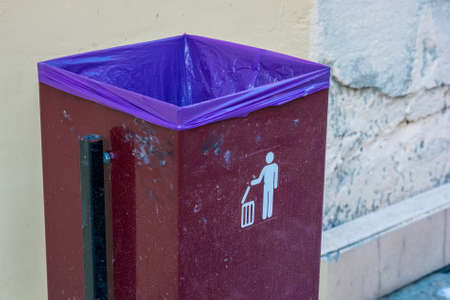 Close up red metal garbage bin with white sign onの写真素材