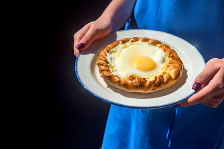 Close up woman holds plate with khachapuri