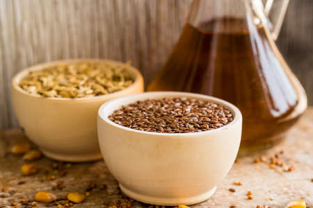 Bowl with flax seeds and glass jar with seed oil organic food conceptの写真素材
