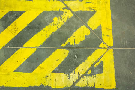 Close up yellow stripes prohibiting parking on grey surfaceの写真素材