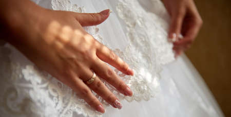 Bride's hands touching the dress close-up imageの写真素材