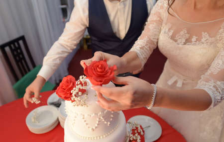 Bride and groom decorate wedding cakeの写真素材