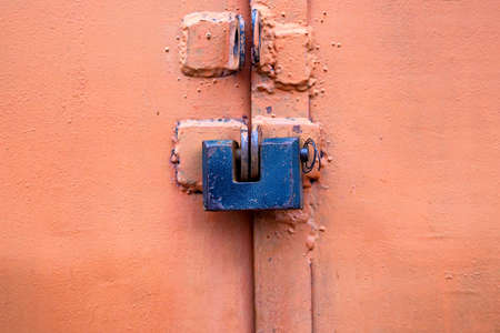 Old metal lock on pink garage door close