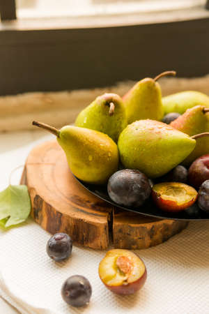 Studio shot plums and pears on plate heathy diet