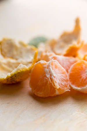 Closeup pieces of peeled tangerine on wooden boardの写真素材