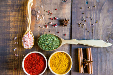 Various colorful herbs and spices on wooden tableの写真素材