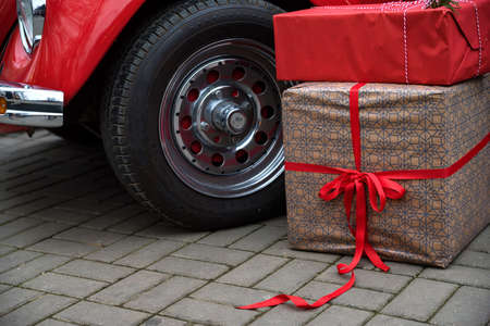 Giftboxes lie on ground next to red retro carの写真素材