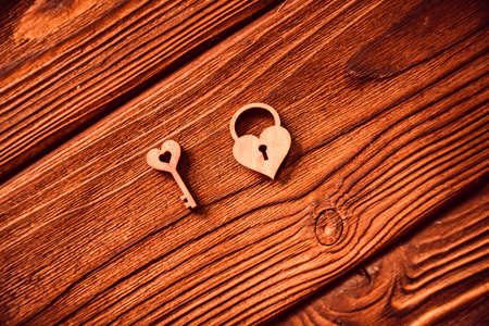 Top view small wooden key to heart and heart-shaped lock on wooden background, Valentine's Day conceptの写真素材