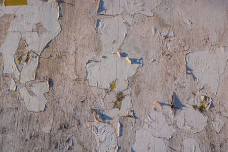Cracked paint on grey concrete surface