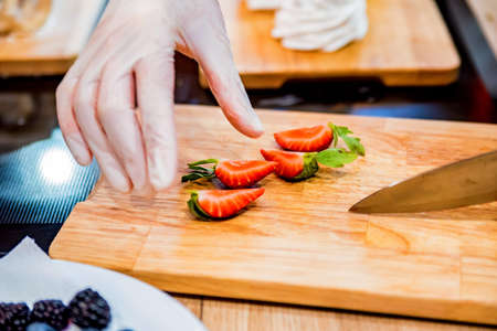 Cutting strawberry on wooden board closeの写真素材