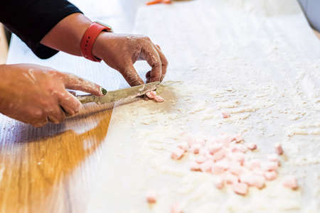 Woman hands cut white marshmallowの写真素材