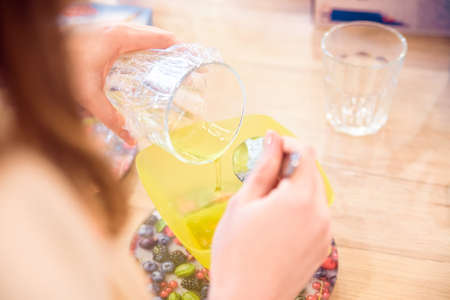 Mixing honey in plastic container while cooking
