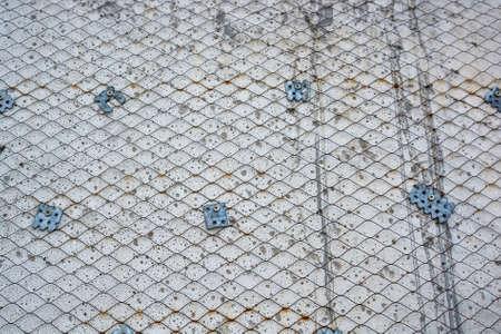 Plaster wall with metal grid mesh on it