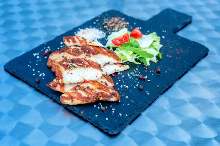 Grilled turkey fillet and vegetables in restaurantの写真素材