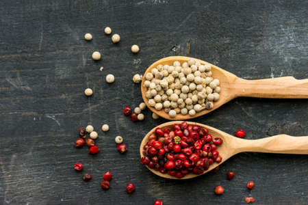 Two wooden spoons with pink and white peppercornの写真素材