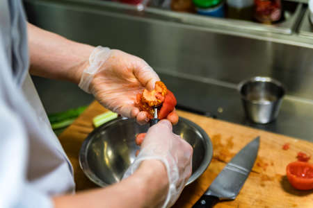 Chef scoops out tomato at cooking seminarの写真素材
