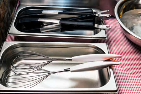 Metal and plastic kitchen tools lie in tray