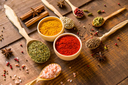 Various colorful herbs and spices on wooden tableの写真素材