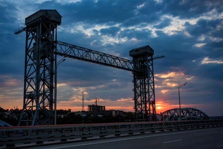 View of modern concrete bridge over river at sunsetの写真素材