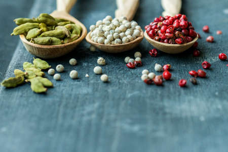 Close up three wooden spoons with colorful spicesの写真素材