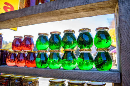 Jars with red and green honey for sale as souvenir in outdoors marketの写真素材