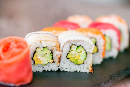 Rainbow sushi roll on tray with ginger close upの写真素材