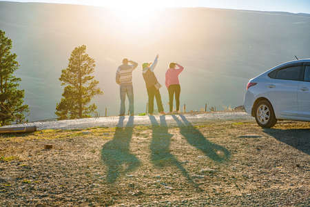 Back view family of tourists enjoy view in mountainsの写真素材