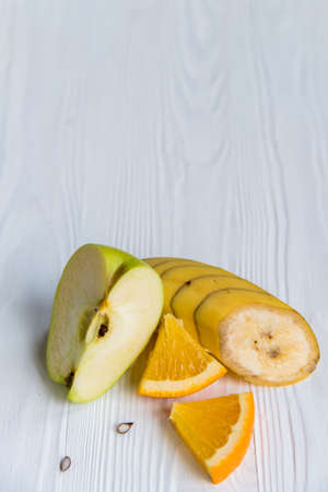Sliced apple, orange and banana on whiteの写真素材